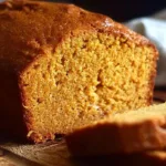 Slice of homemade easy pumpkin bread on a wooden table.