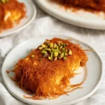 Delicious Knafeh with crispy pastry and cheese, topped with sweet syrup.