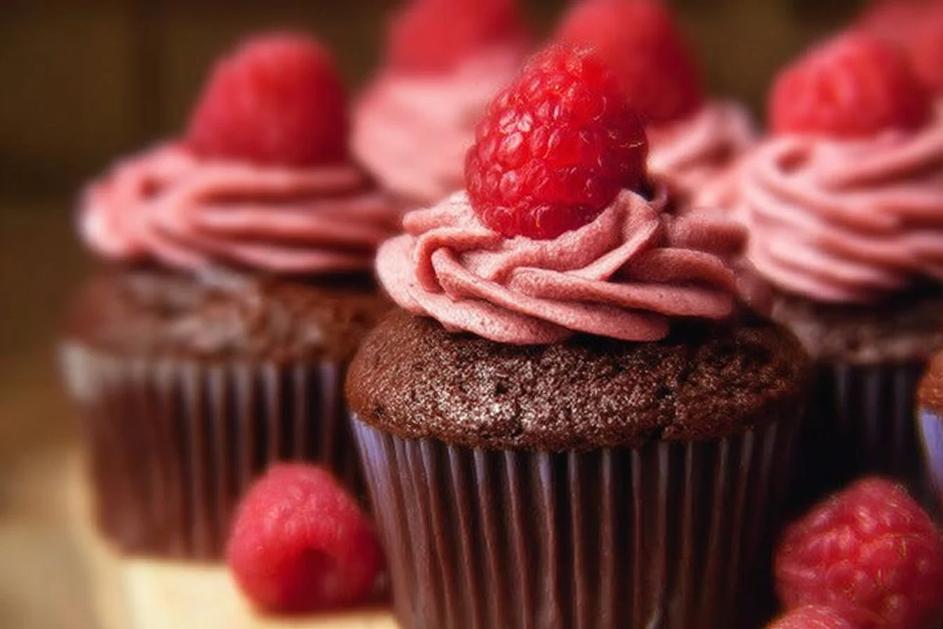 Chocolate Raspberry Cupcakes topped with fresh raspberries and chocolate icing