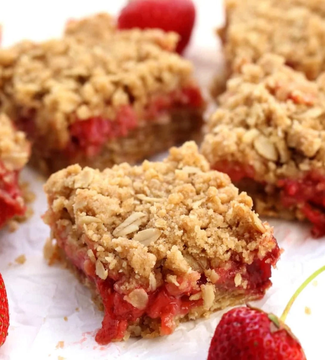 Vegan strawberry oat bars topped with fresh strawberries and oats