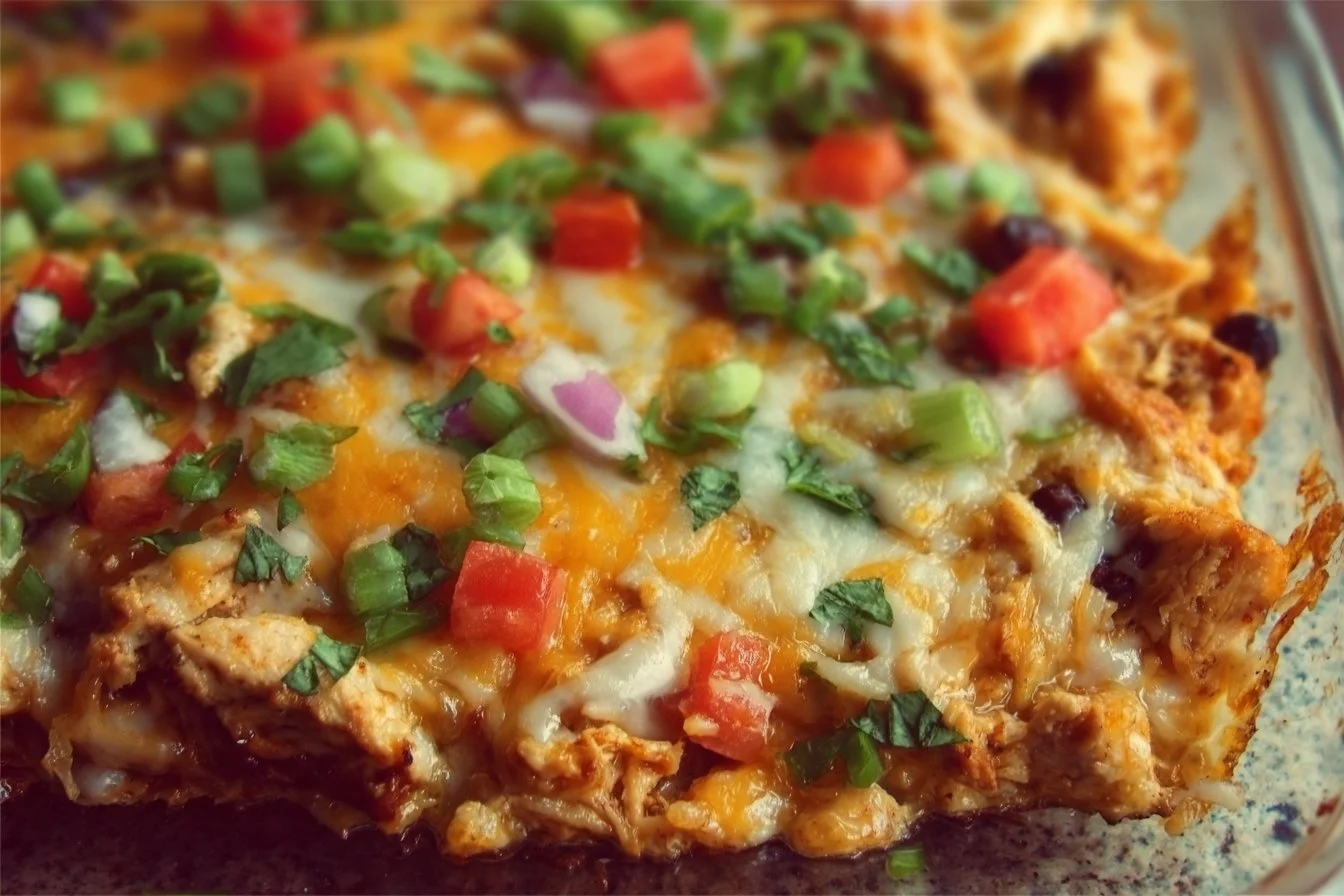 Healthy chicken burrito casserole with toppings in a baking dish